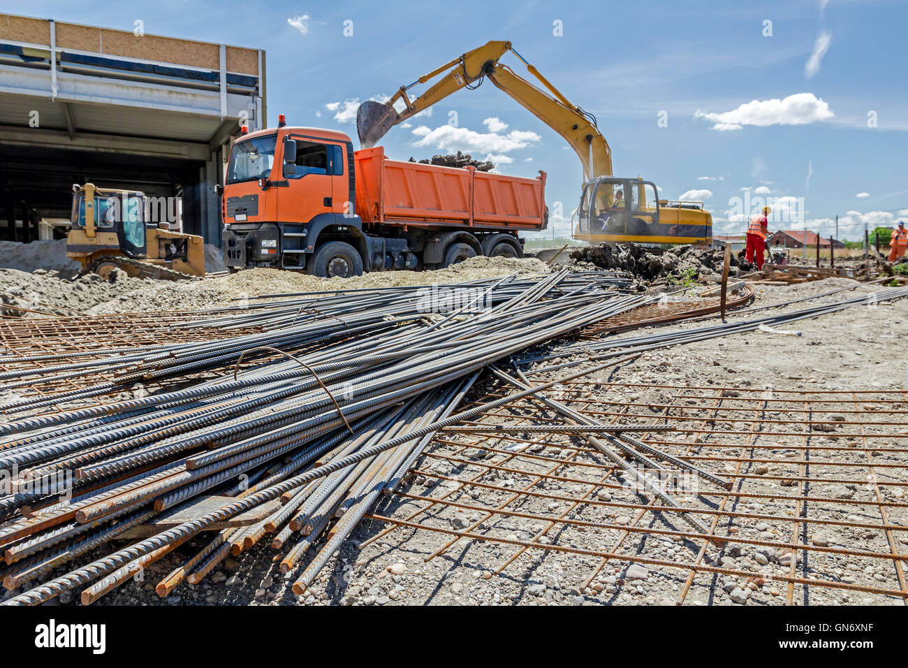 View on rusty square reinforcement for concrete, steel bars, construction site is in background. Stock Photo