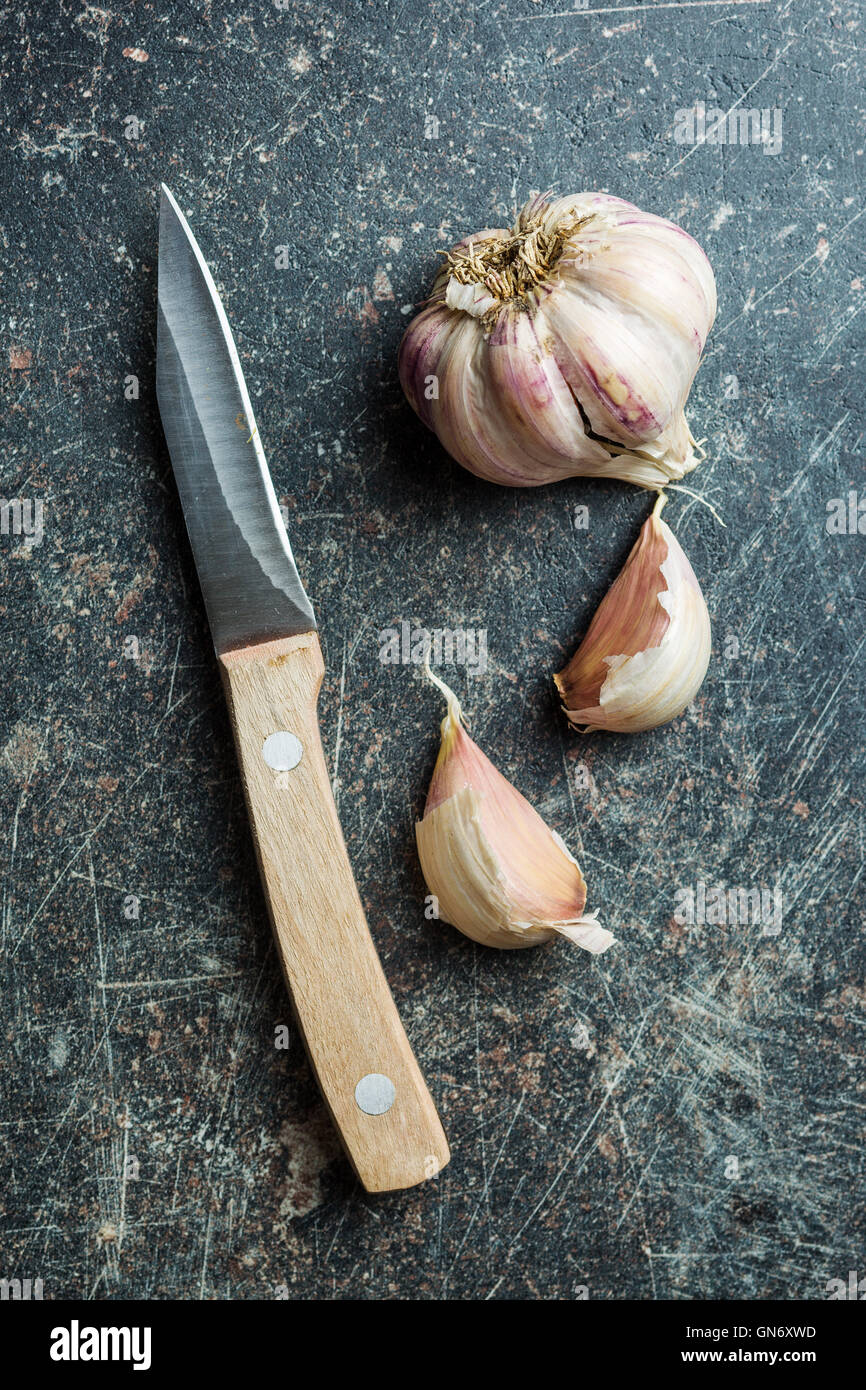 The fresh garlic with knife on kitchen table Stock Photo - Alamy