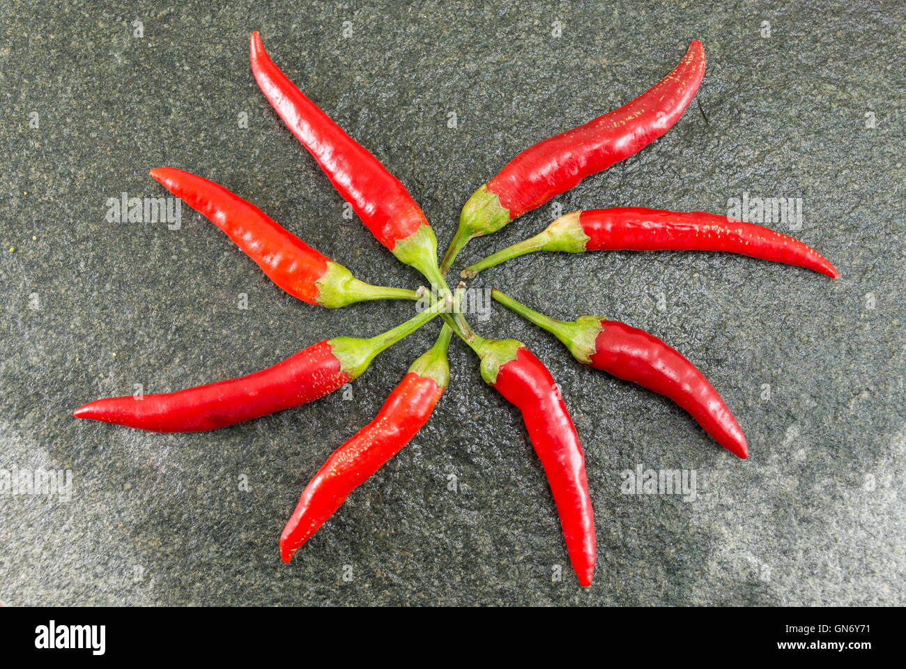 Red hot raw peppers on stone background Stock Photo