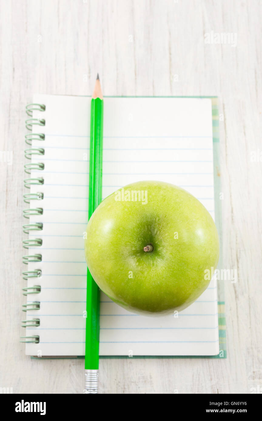Apple on top of a notebook. School time Stock Photo