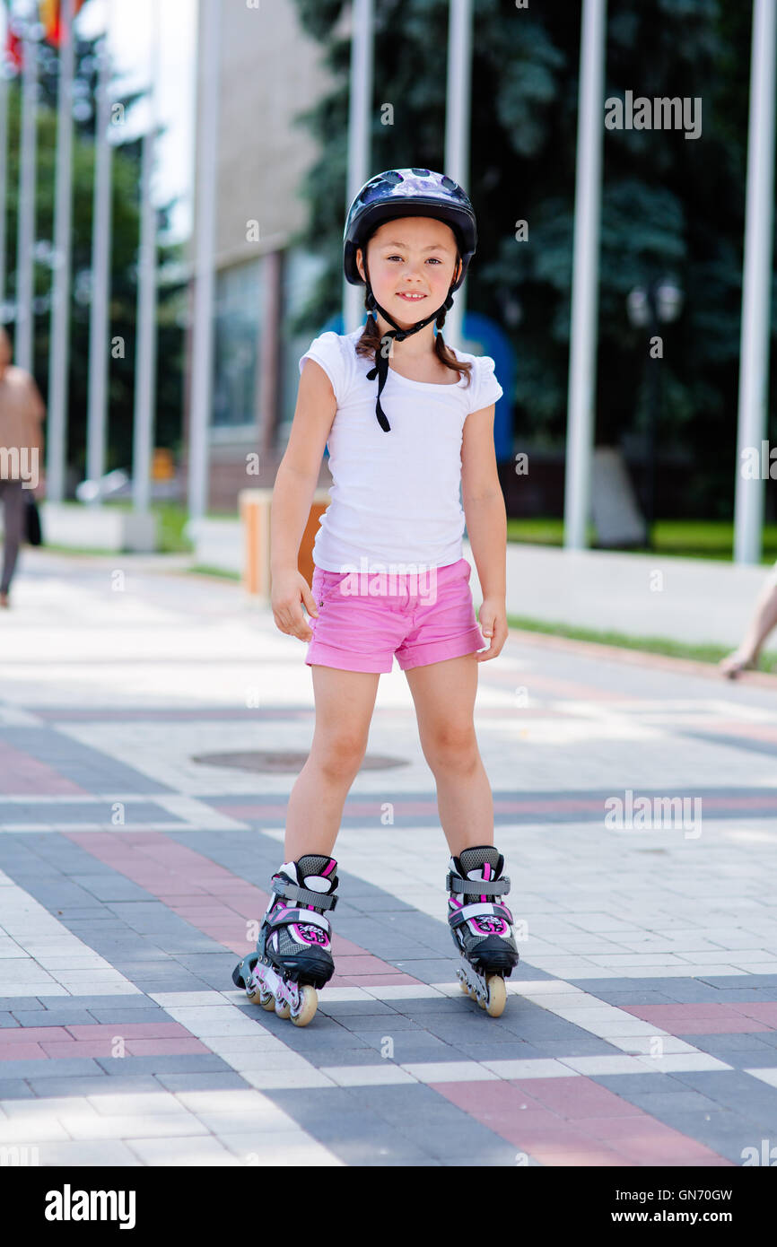 Little girl on roller skates in helmet at a park Stock Photo Alamy