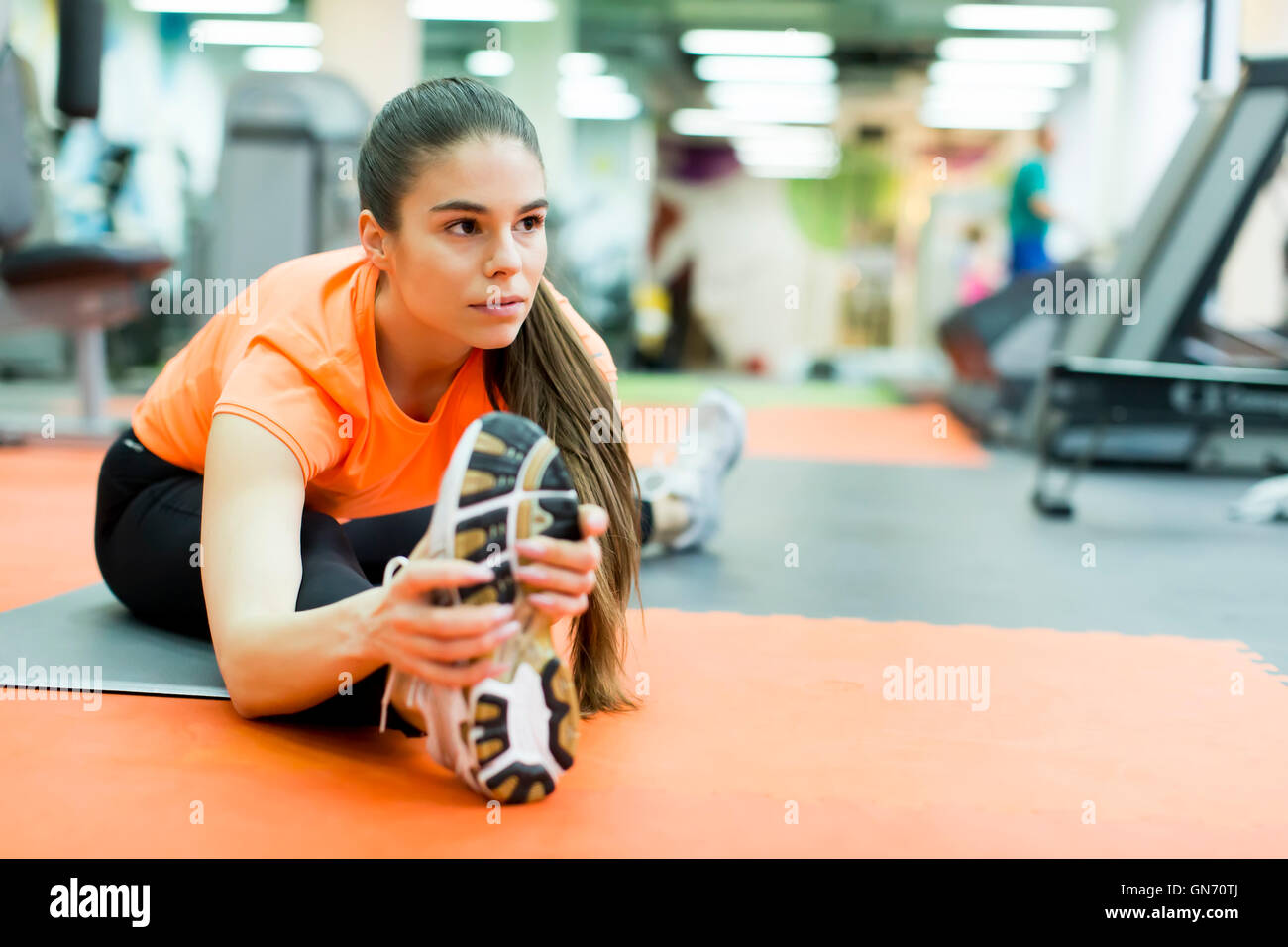 Young woman doing stretching exercises at the fitness center Stock Photo