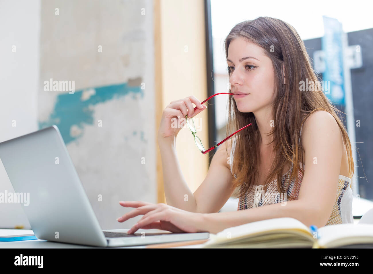 Pretty young woman working on laptop in the office Stock Photo - Alamy