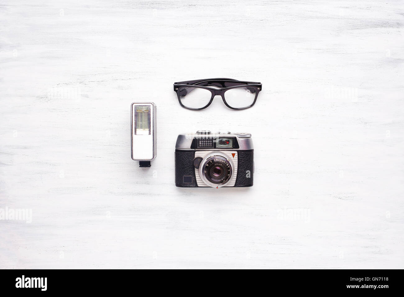 Top view of vintage camera and hipster glasses on a white wooden table with copyspace. Stock Photo