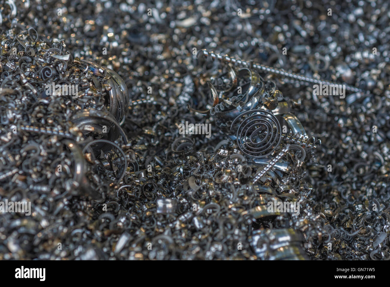 Close shot of metal turnings / industrial swarf from CNC machining operations. Industrial waste, metal waste, metal texture. Stock Photo