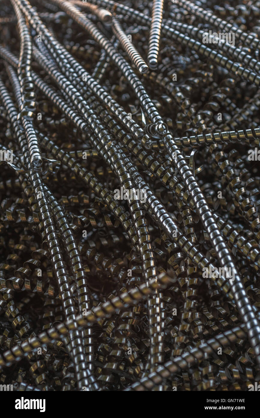 Close shot of metal turnings / industrial swarf from CNC machining operations. Industrial waste, metal waste, metal texture. Stock Photo