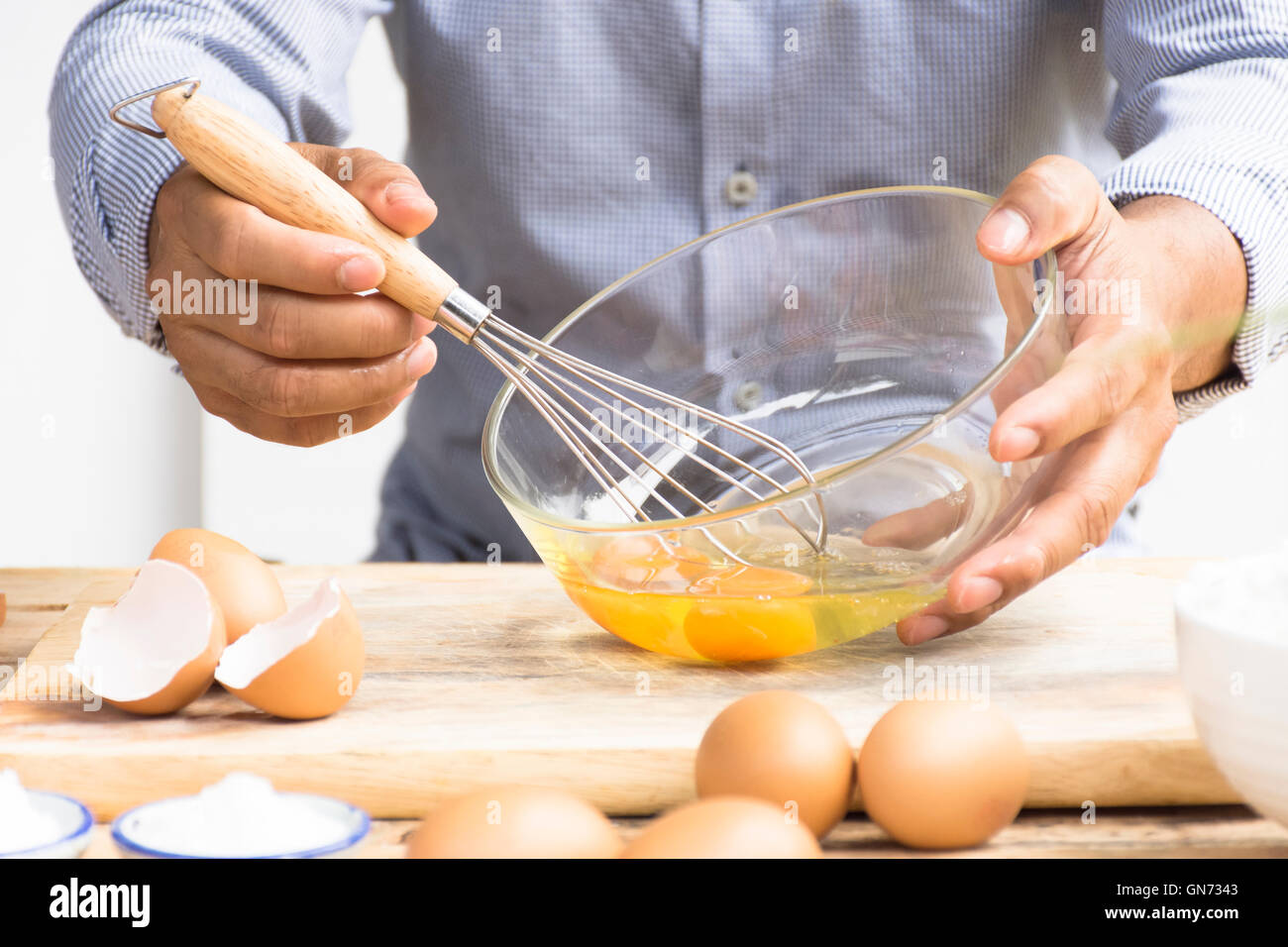 Man whisking egg  in his kitchen.Zoom in Stock Photo