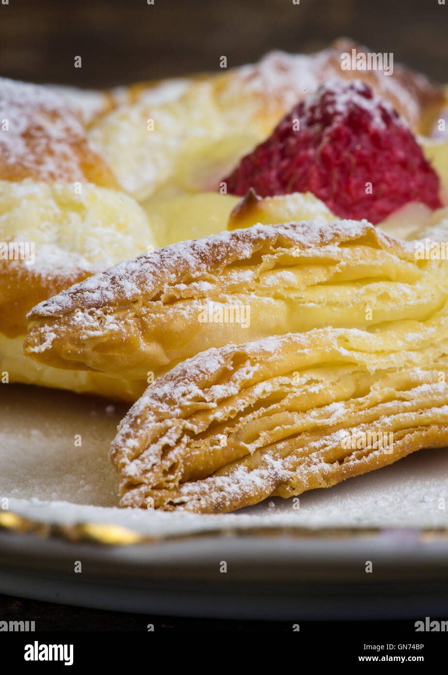 Homemade danish puff pastry pinwheels with vanilla pastry cream and raspberries and icing sugar Stock Photo