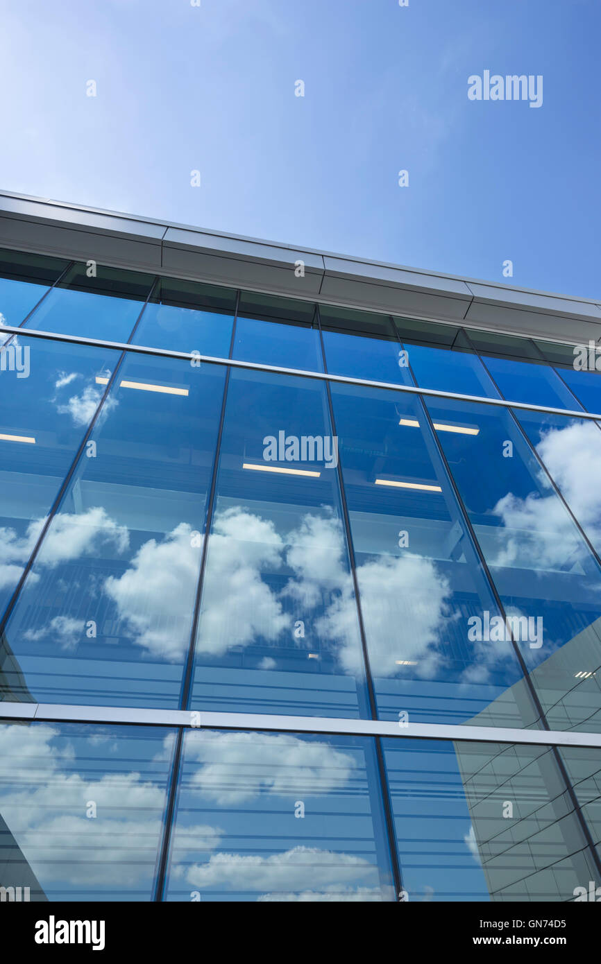 PUFFY WHITE CLOUDS BLUE SKY REFLECTED ON GLASS OFFICE BUILDING WINDOWS Stock Photo