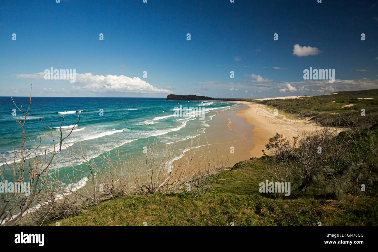 Stunning view of vast sandy beach, turquoise waters of Pacific Ocean, forested dunes & Indian Head in distance on Fraser Island Australia Stock Photo