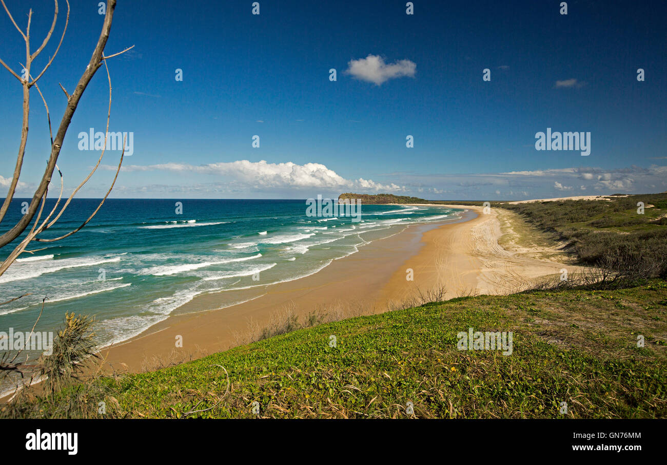 Stunning view of vast sandy beach, turquoise waters of Pacific Ocean, forested dunes & Indian Head in distance on Fraser Island Australia Stock Photo