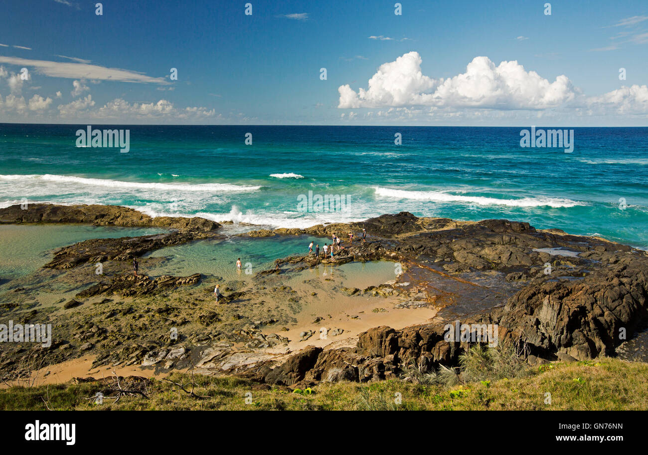 Spectacular view of turquoise waters & waves of Pacific Ocean rolling into rocky Champagne Pools on rugged coast, Fraser Island Stock Photo