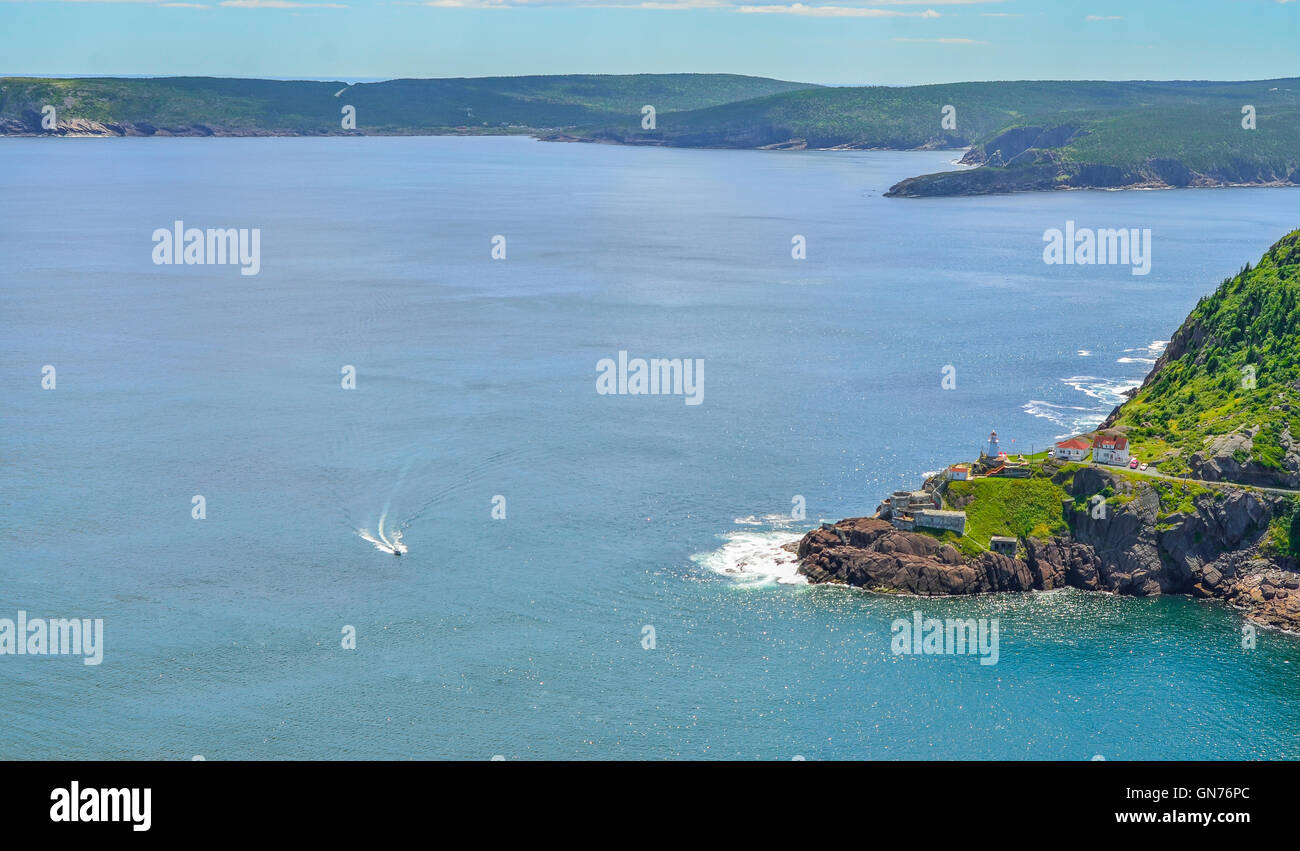 A speeding boat passing a Canadian National Historic Site, Fort Amherst in St John's Newfoundland. Stock Photo