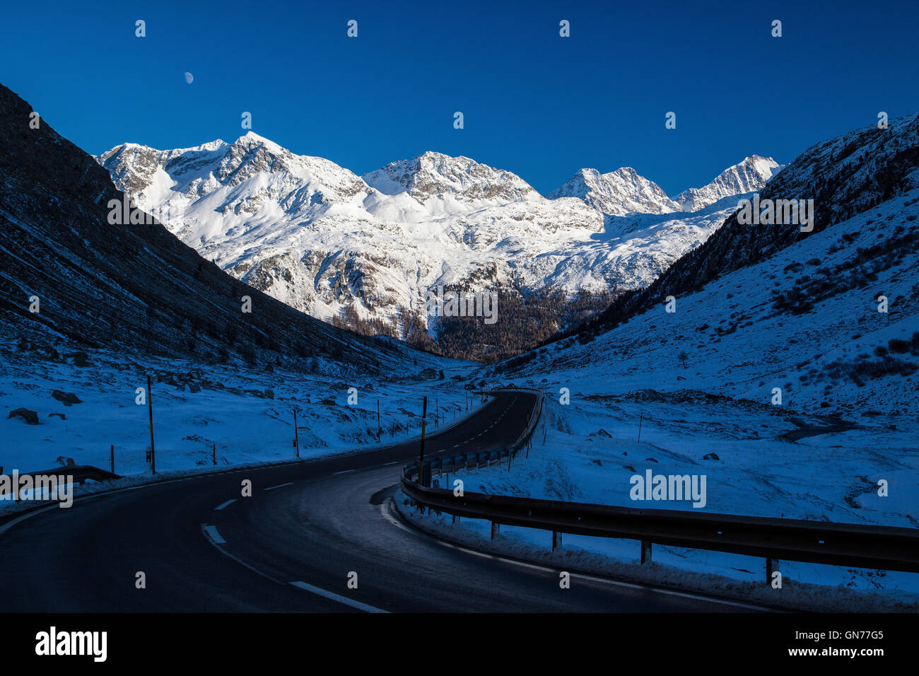 The road towards the snow capped mountains and the blue sky Julierpass ...