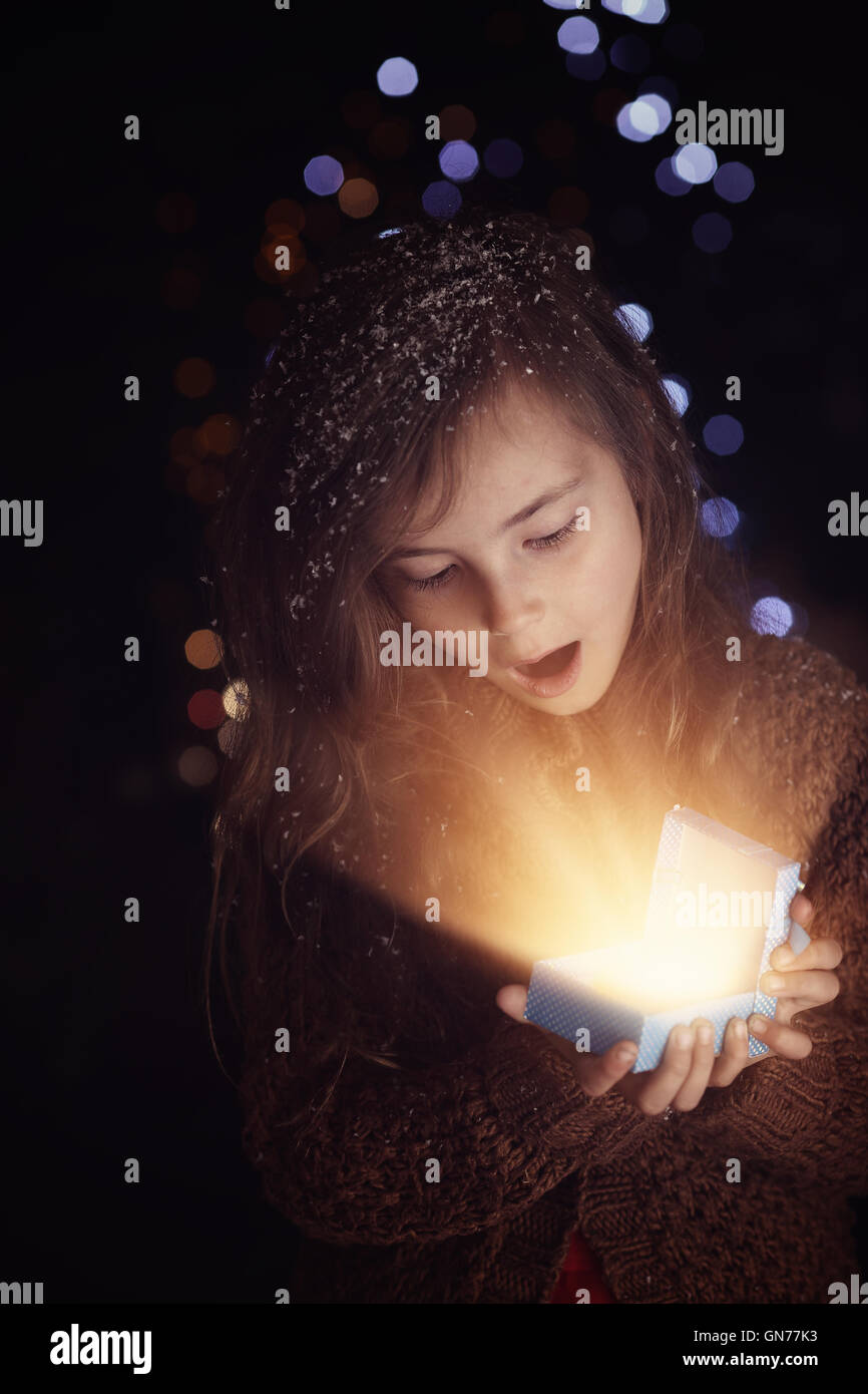 young girl opens Christmas present Stock Photo