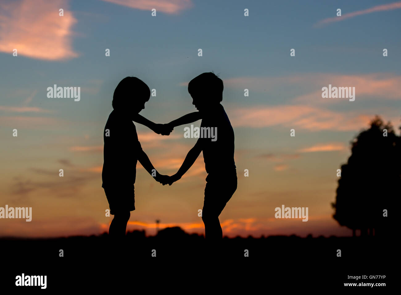Silhouette Of Two Children Boy Brothers Making Heart Shape With Hands Against The Sunset Sky Summertime Stock Photo Alamy