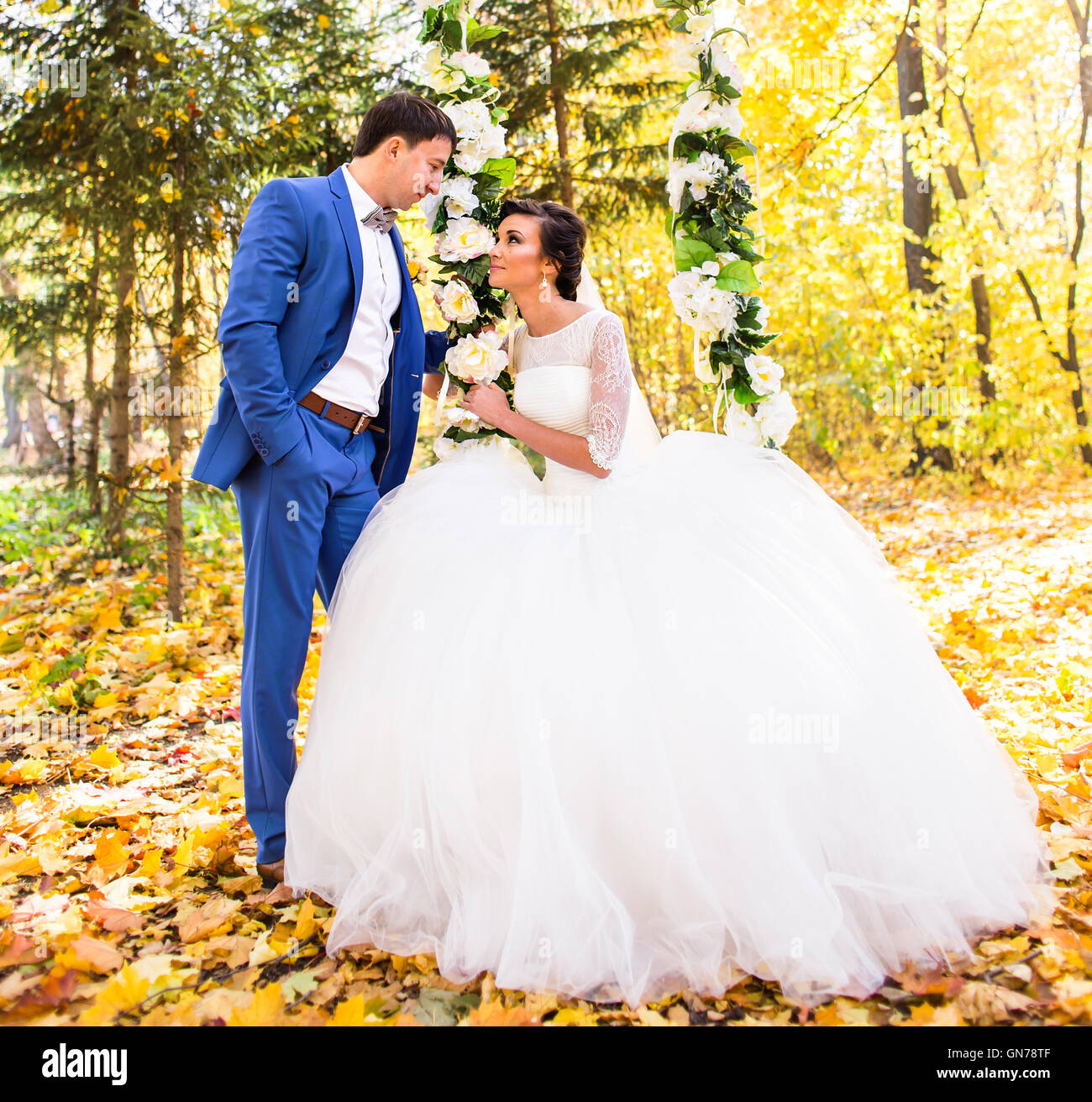The bride and groom on a swing in autumn park Stock Photo - Alamy