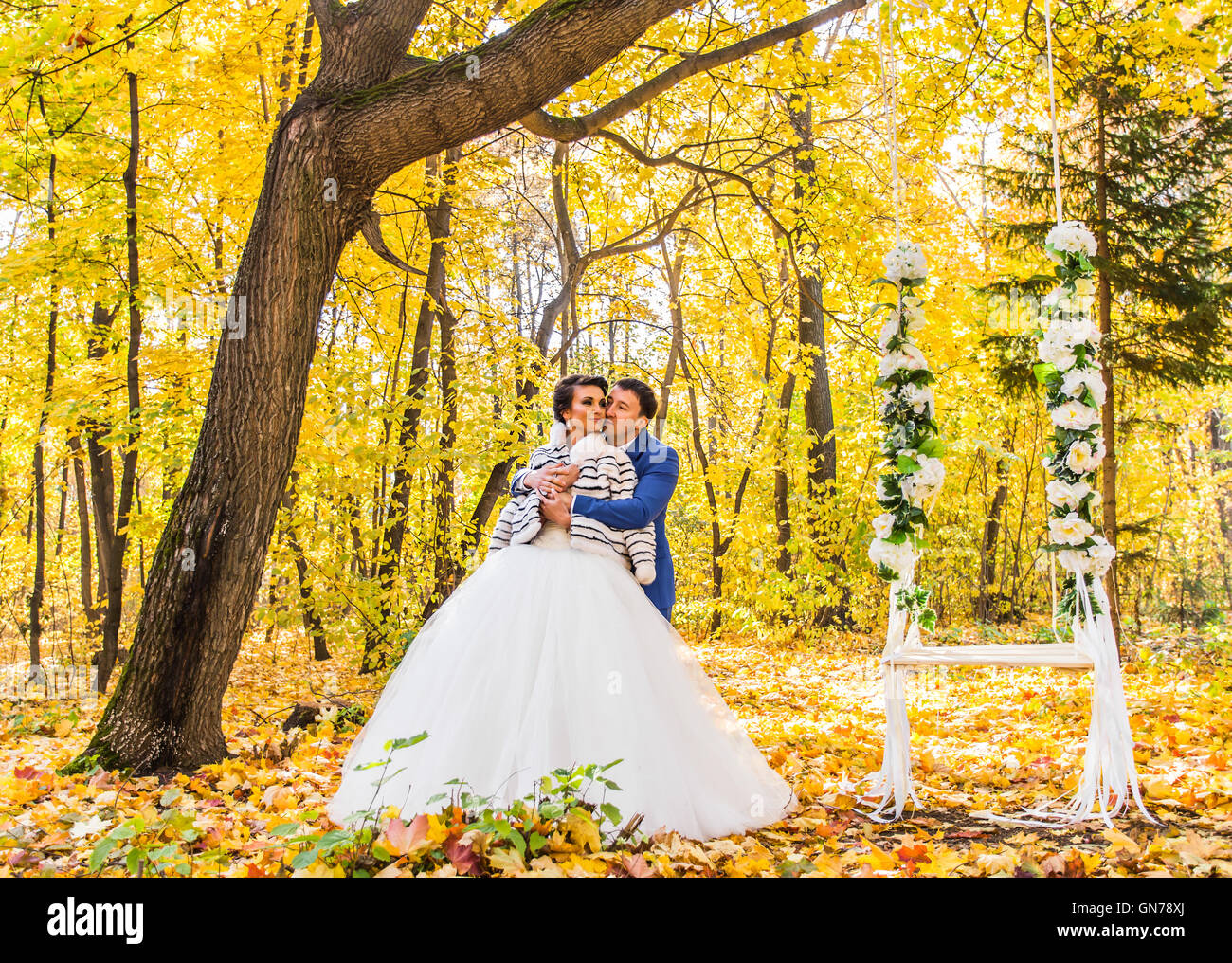 The bride and groom on a swing in autumn park Stock Photo - Alamy