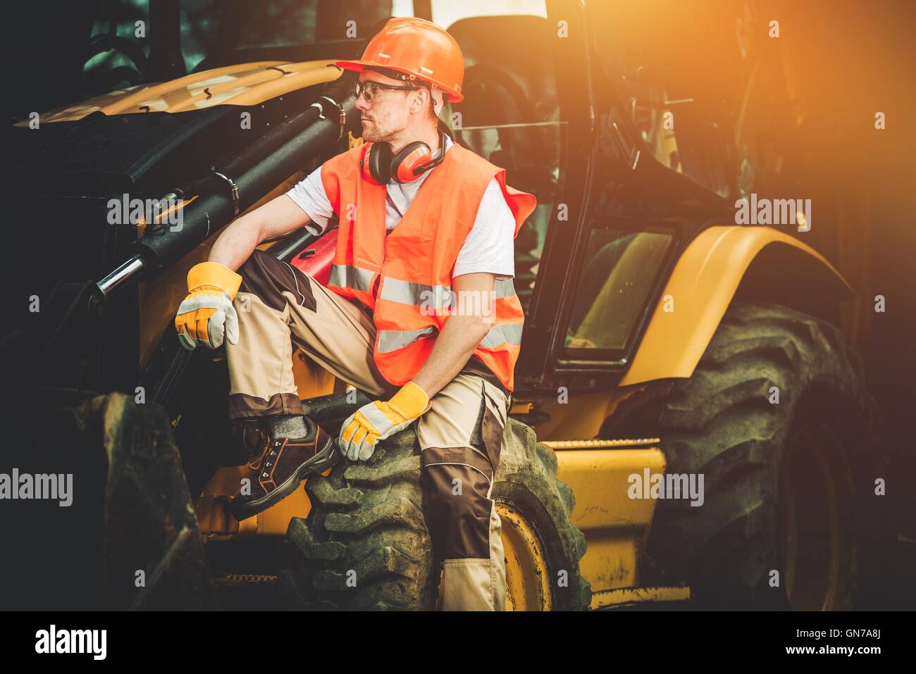 Bulldozer Construction Worker Resting on His Heavy Duty Machinery. Stock Photo