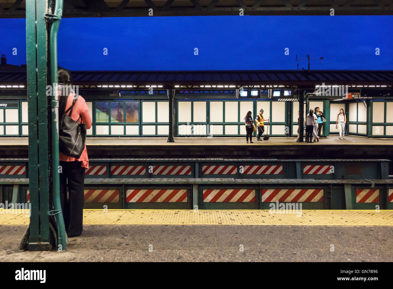 New York City,NY NYC Queens,Jackson Heights,Roosevelt Avenue,74th Street-Broadway,subway,station,MTA,platform,above-ground,adult adults,woman female w Stock Photo