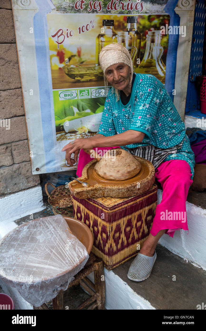 Essaouira, Morocco.  Woman Grinding Argan Nuts to Make Oil. Stock Photo