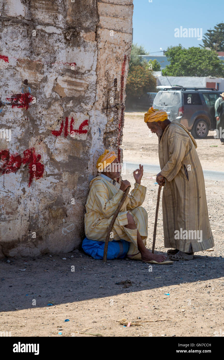 Morocco.  Two Old Men Talking in the Shade,  Had Draa Market, Essaouira Province. Stock Photo
