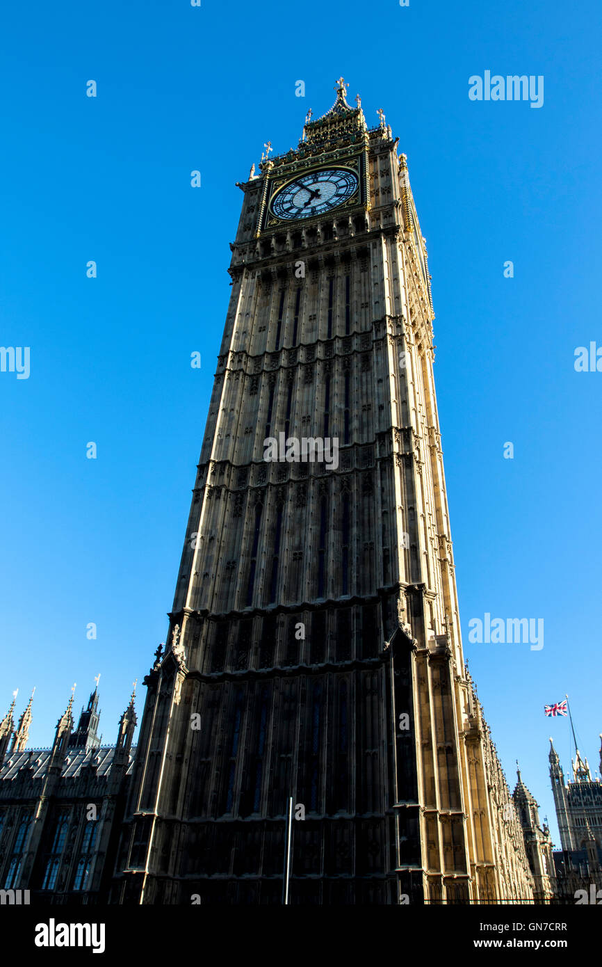 Tourists on open top bus looking at Big Ben at the north end of the Palace of Westminster in London in summer with blue sky Stock Photo