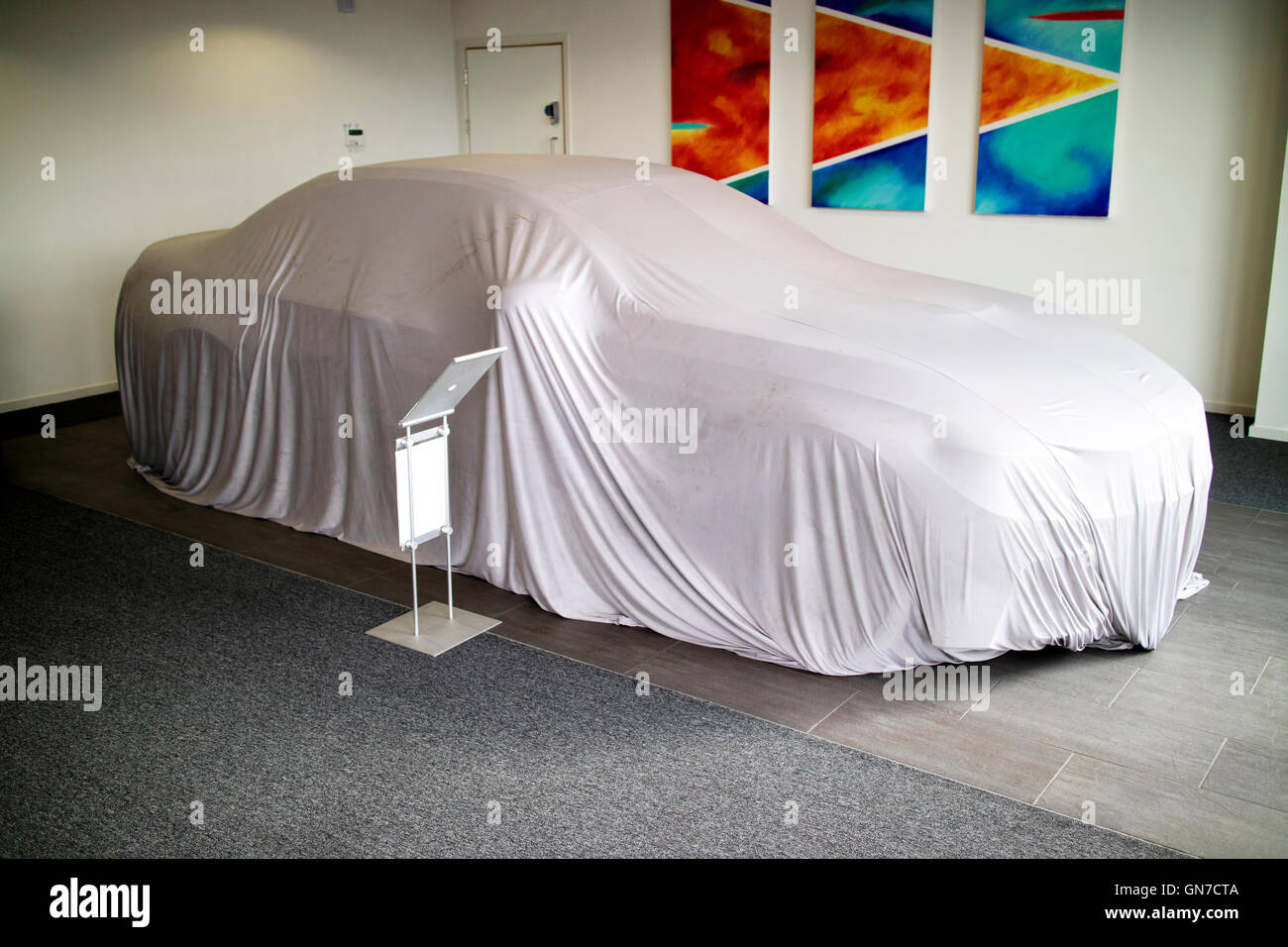 Brand new 2016 F83 BMW M4 convertible 2 door coupe under cover at Williams Rochdale BMW showroom awaiting very excited customer Stock Photo