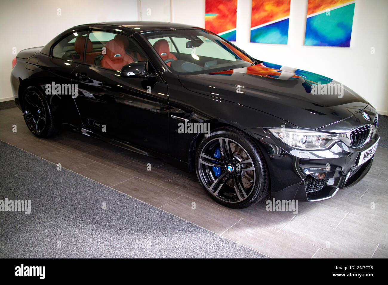 Brand new 2016 F83 Black BMW M4 convertible 2 door coupe with Sakhir Orange red leather at Williams Rochdale BMW showroom Stock Photo