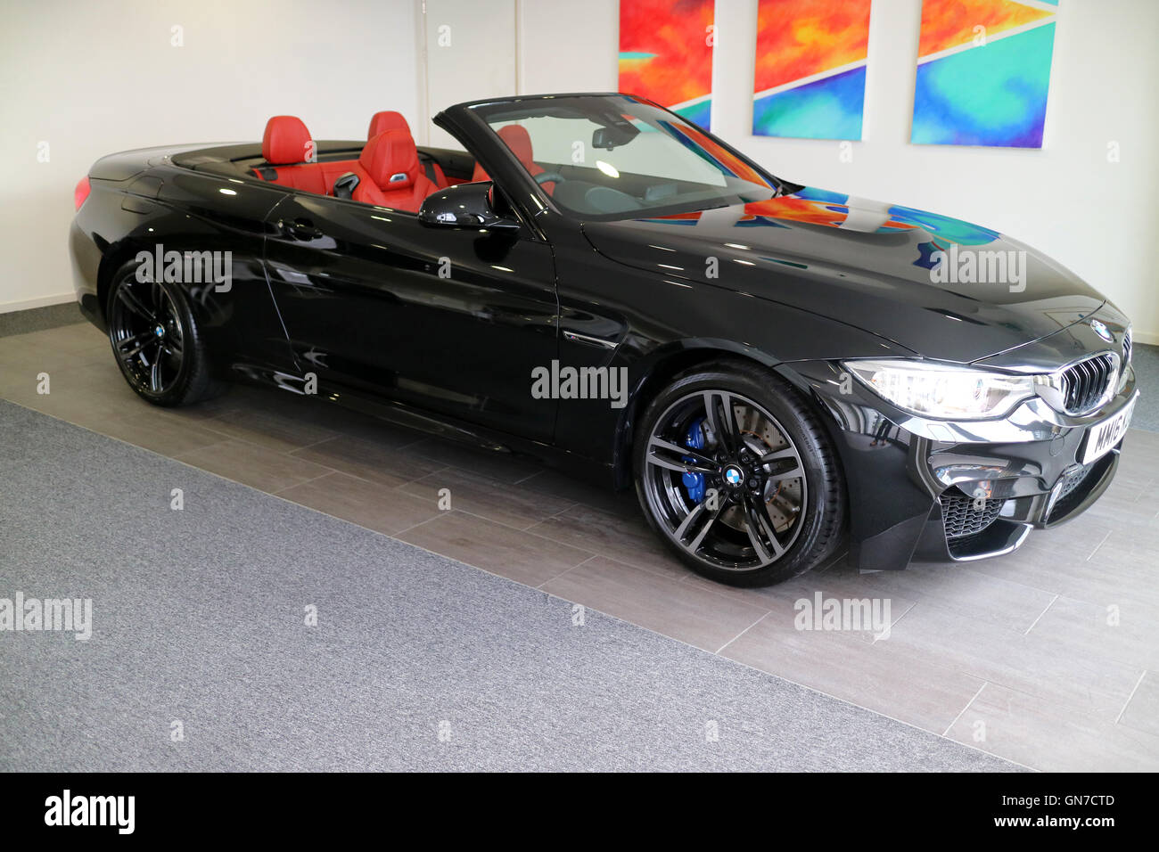 Brand new 2016 F83 Black BMW M4 convertible 2 door coupe with Sakhir Orange red leather at Williams Rochdale BMW showroom Stock Photo