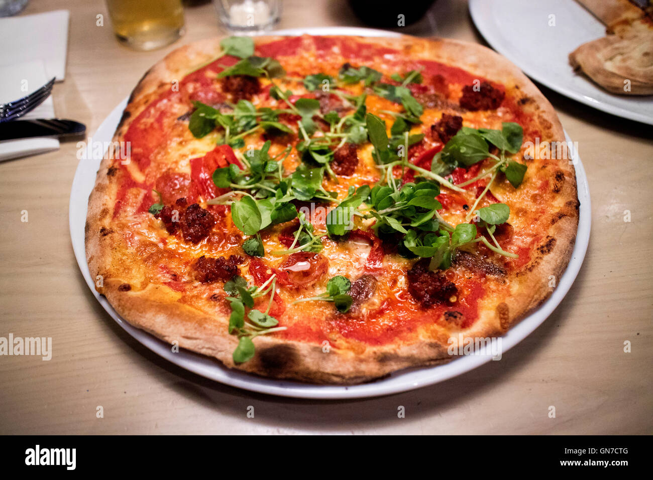 Meat feast pizza with pepperoni and ground beef topped with rocket