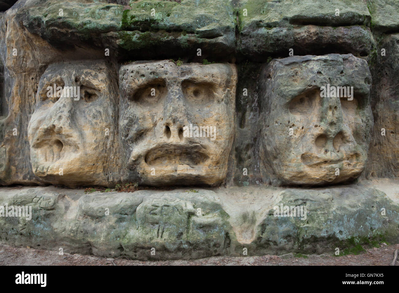Stone faces carved by Czech sculptor Vaclav Levy in the sandstone rocks in the forest outside the village of Zelizy in Central Bohemia, Czech Republic. This complex of sculptural works known as the Harfenice (Harpist) was created by Vaclav Levy during the 1840s together with the Devil's Heads and the Klacelka Cave located in the forest nearby. Stock Photo