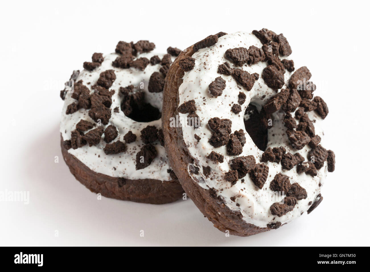 two Oreo doughnuts made with Oreo cookie pieces & with creme filling isolated on white background Stock Photo