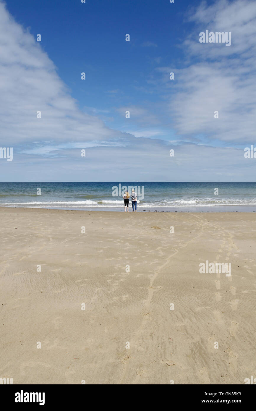 Couple enjoying the tranquility of Overstrand Beach in Norfolk Stock Photo