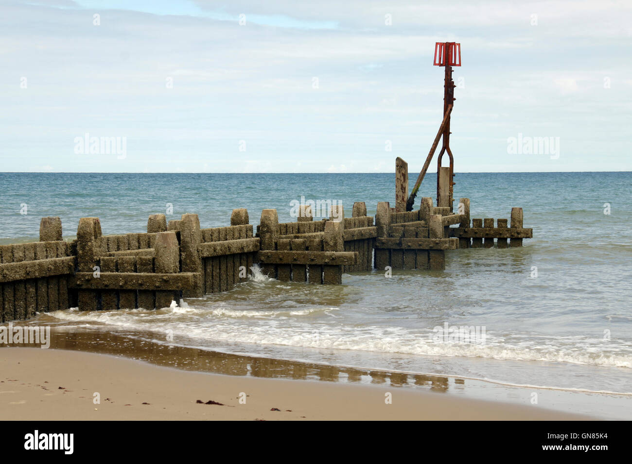 A groyne stretching out to sea on Overstrand Beach in Norfolk Stock Photo