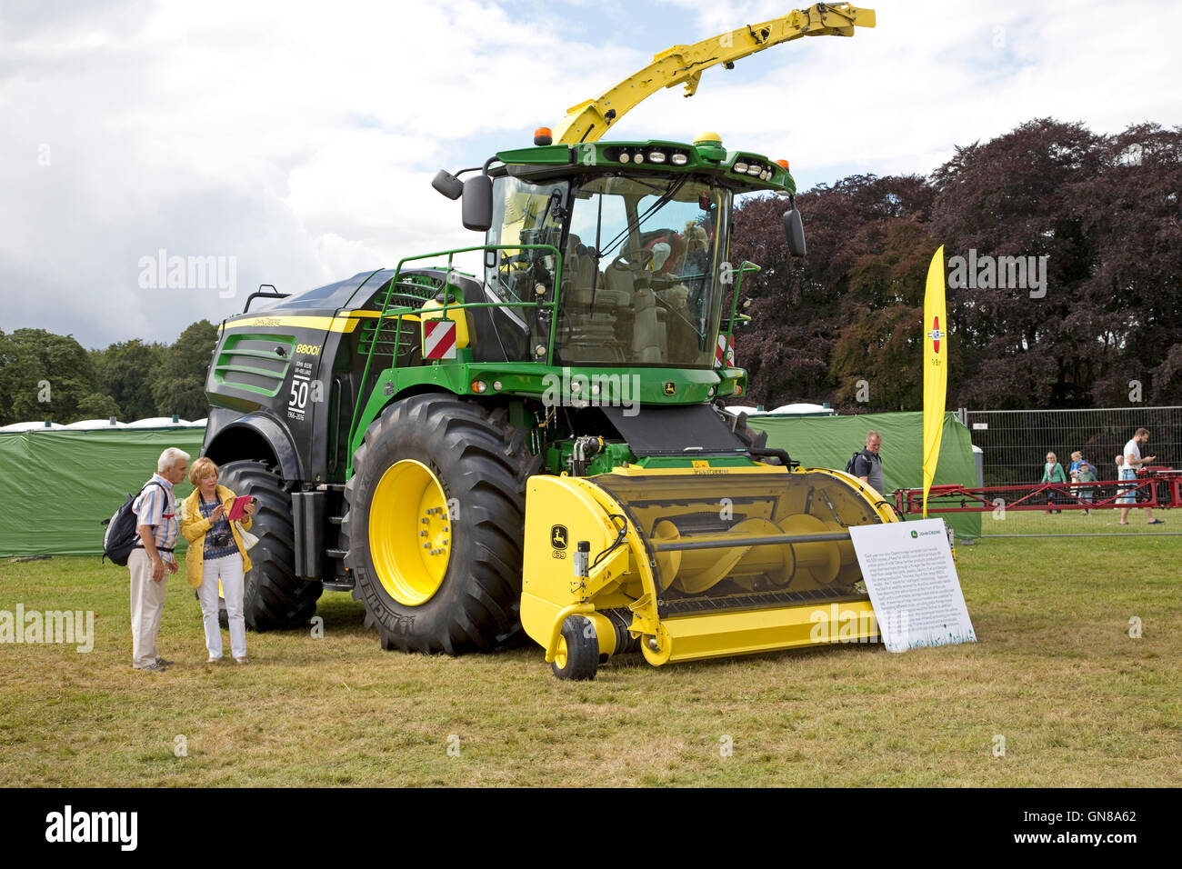 Couple looking at new John Deere forage harvester Countryfile Live Blenheim UK Stock Photo