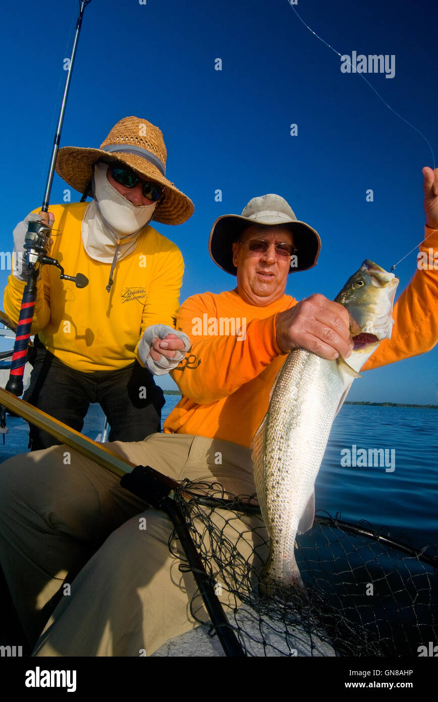 Two anglers admire a giant "Gator" trout caught in Florida's Mosquito Lagoon and Indian River