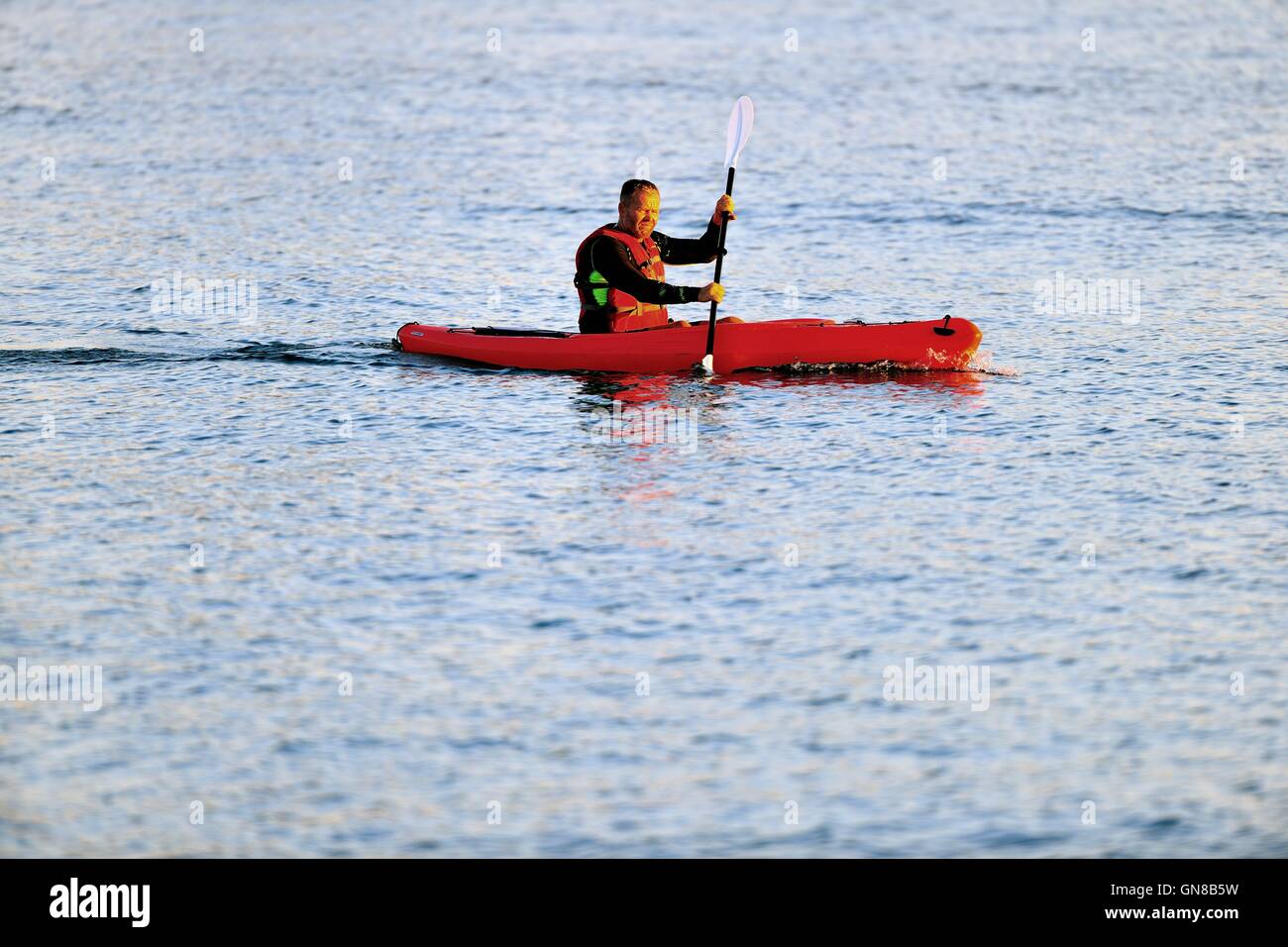 A lone man in a kayak venturing out into the vastness of Lake Michigan