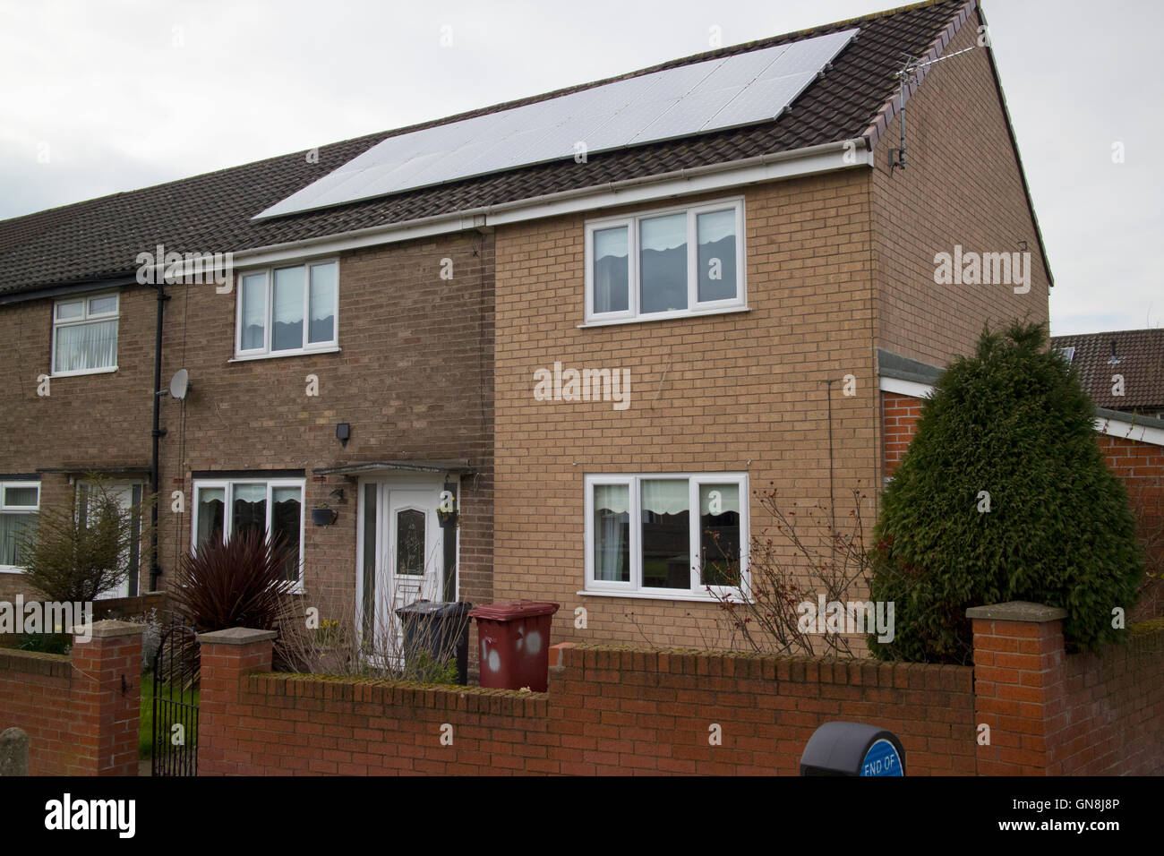 solar panels on the roof of an end terrace property on a housing estate on overcast day Liverpool Merseyside UK Stock Photo