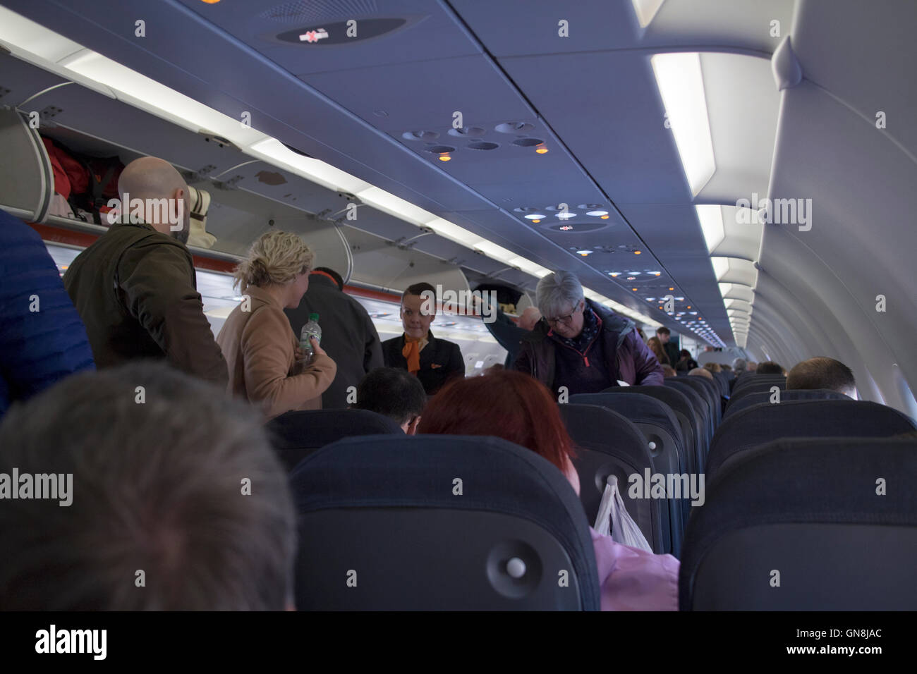 passengers walking down aisle easyjet aircraft Stock Photo