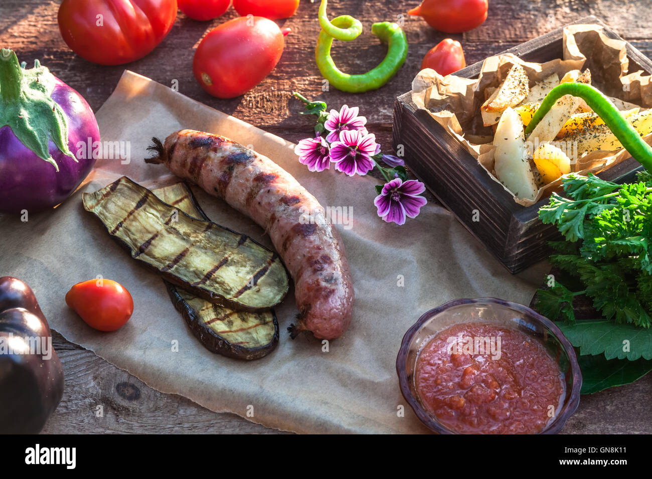 Grilled sausages and vegetables in rustic style. Selective focus Stock Photo