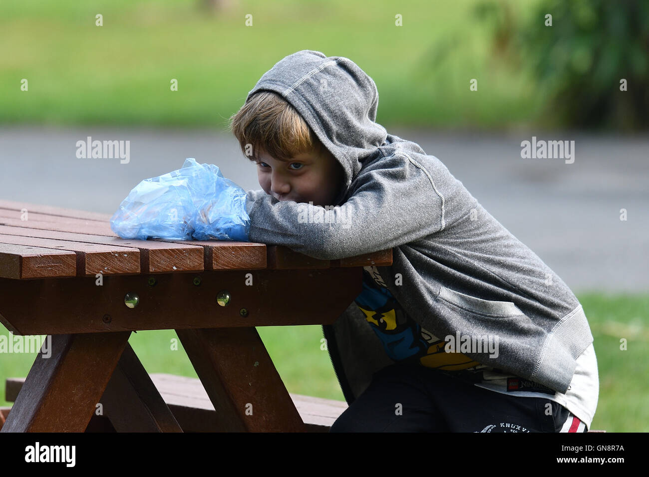 A boy sitting at a picnic bench Stock Photo - Alamy