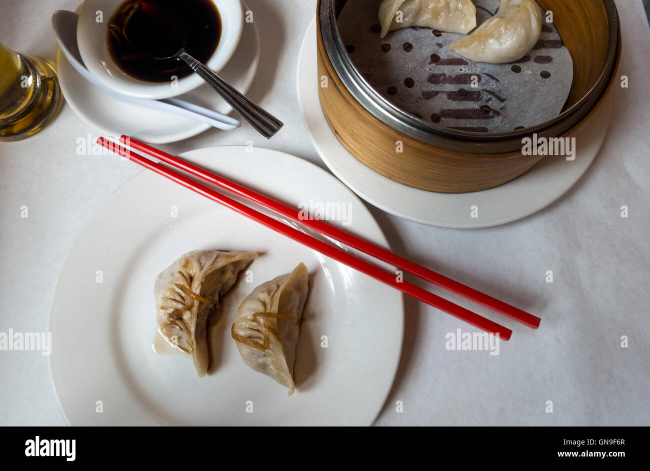 Steamed vegetable dumplings with soy sauce at a table in a Chinese