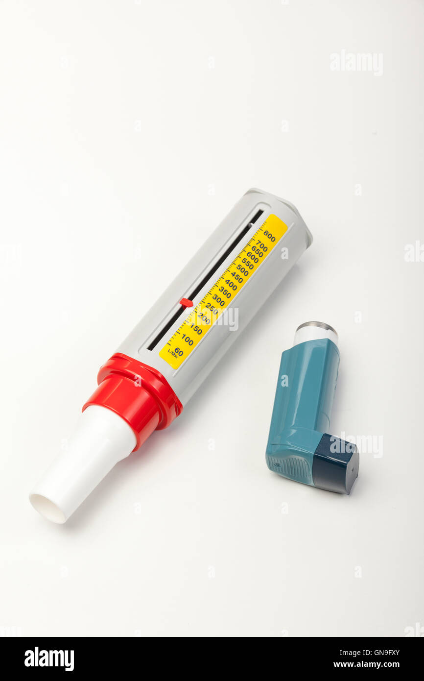 Blue spray reliever inhaler for asthma and a peek flow meter on a portrait whith background Stock Photo