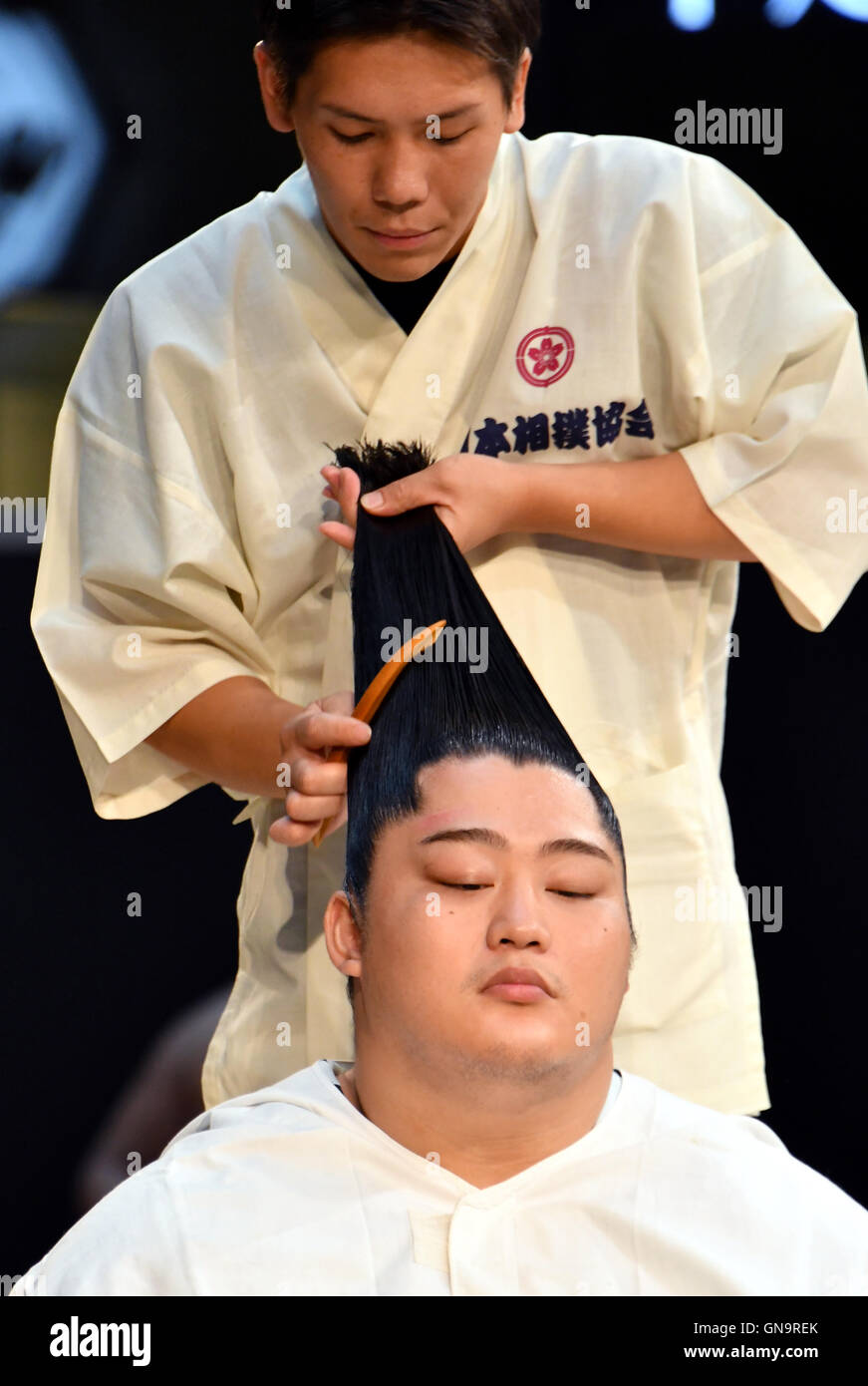 Tokyo, Japan. 28th Aug, 2016. A coiffeur dresses a sumo wrestlers hair in a  demonstration of traditional hairdressing during a promotional event at a  commercial complex next to Tokyo central station on