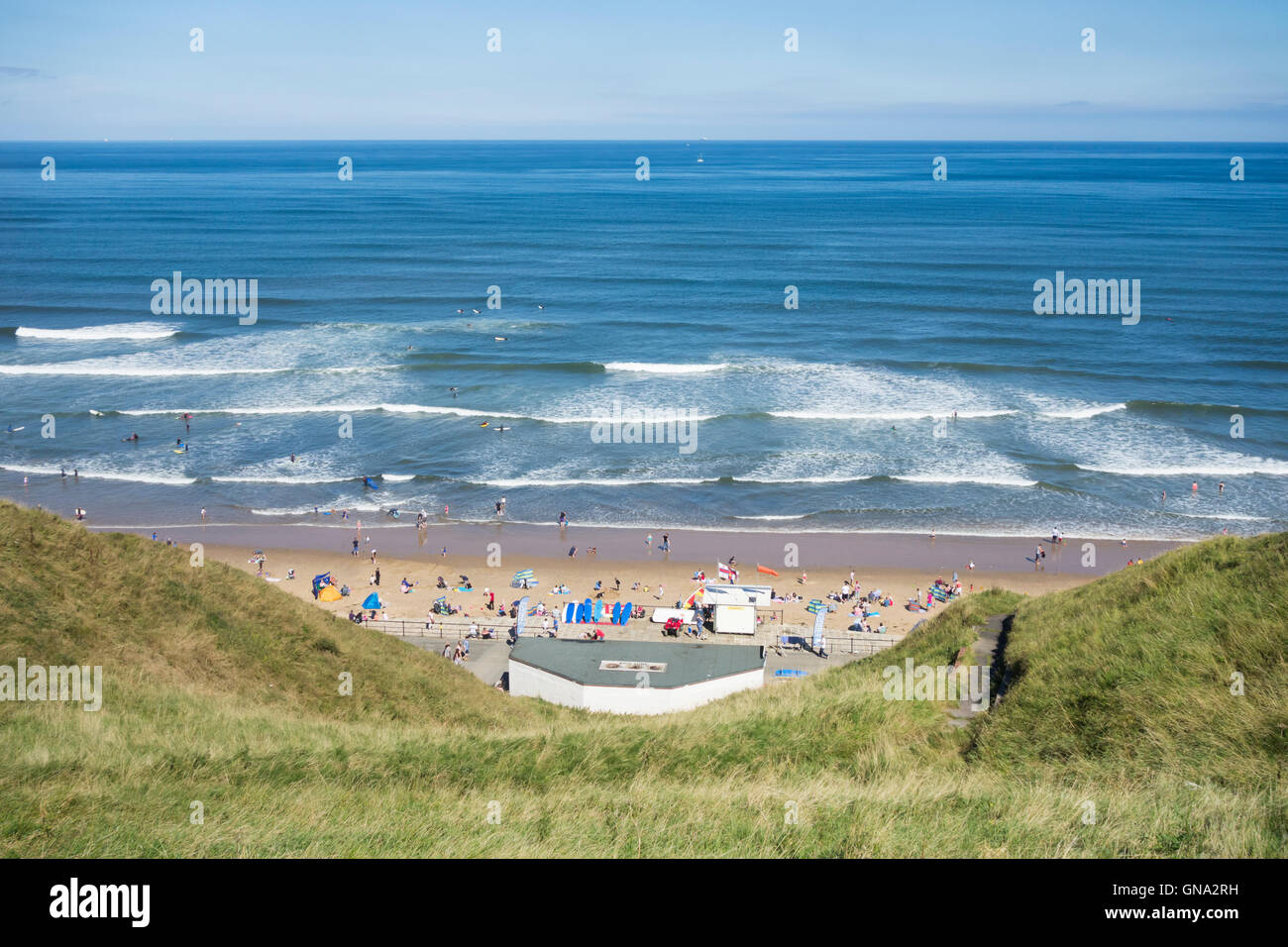 View over Saltburn beach and surf school at high tide from top promenade. Saltburn by the sea, North Yorkshire, England, UK Stock Photo