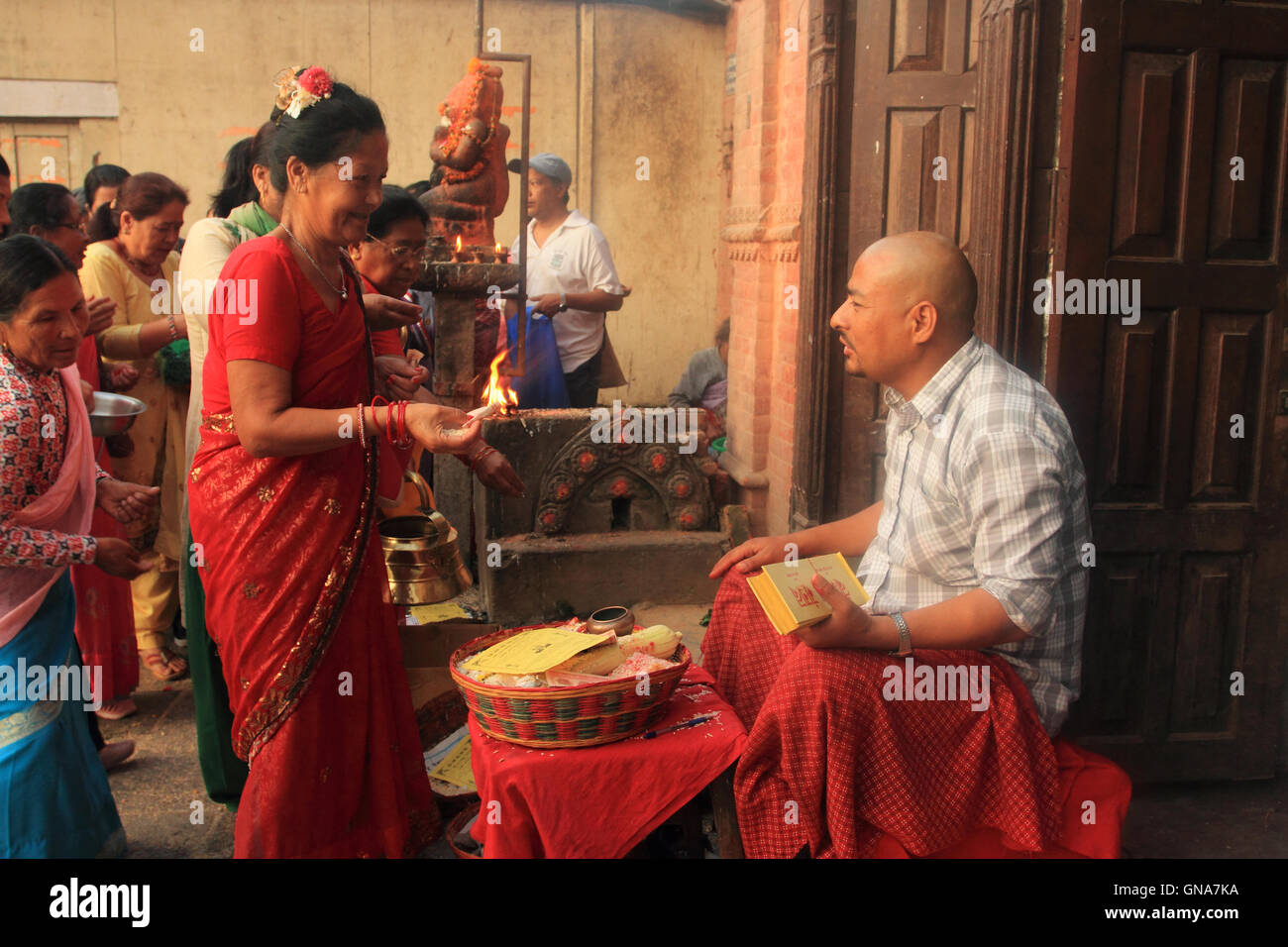 Kathmandu, Nepal. 30th August,2016. A local woman give offering to Newar Buddhist monk on the ocassion of Panchadan in Swoyambhu,Kathmandu. This is a Buddhist festival in which five different elements like rice grains, wheat grains, salt, pulses and money are donaten to Buddhist monk by laity. Stock Photo