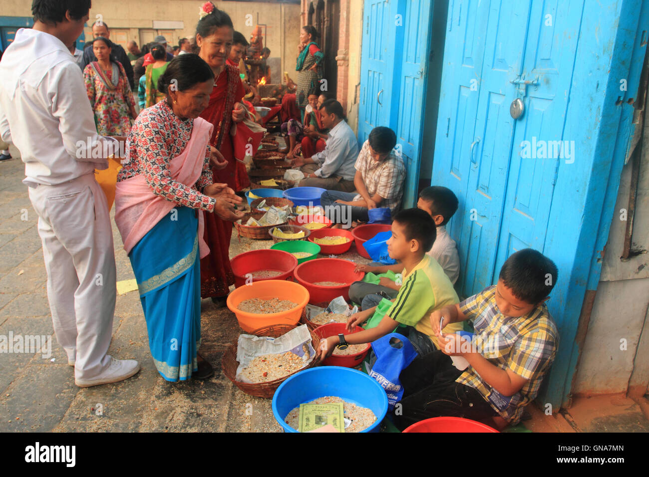 Kathmandu, Nepal. 30th August,2016. A local woman give offering to Newar Buddhist monks on the ocassion of Panchadan. This is a Buddhist festival in which five different elements like rice grains, wheat grains, salt, pulses and money are donaten to Buddhist monk by laity. Stock Photo