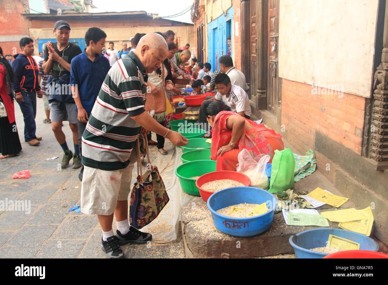 Kathmandu, Nepal. 30th August,2016. A local peopleof Kathmandu give offering to Newar Buddhist monk on the ocassion of Panchadan. This is a Buddhist festival in which five different elements like rice grains, wheat grains, salt, pulses and money are donate to Buddhist monk by laity. Stock Photo