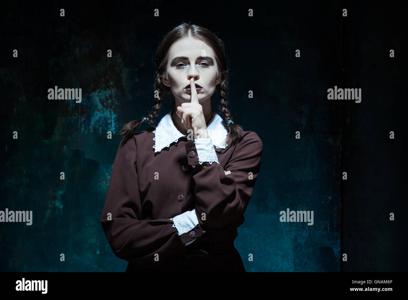 Portrait of a young girl in school uniform as killer woman Stock Photo